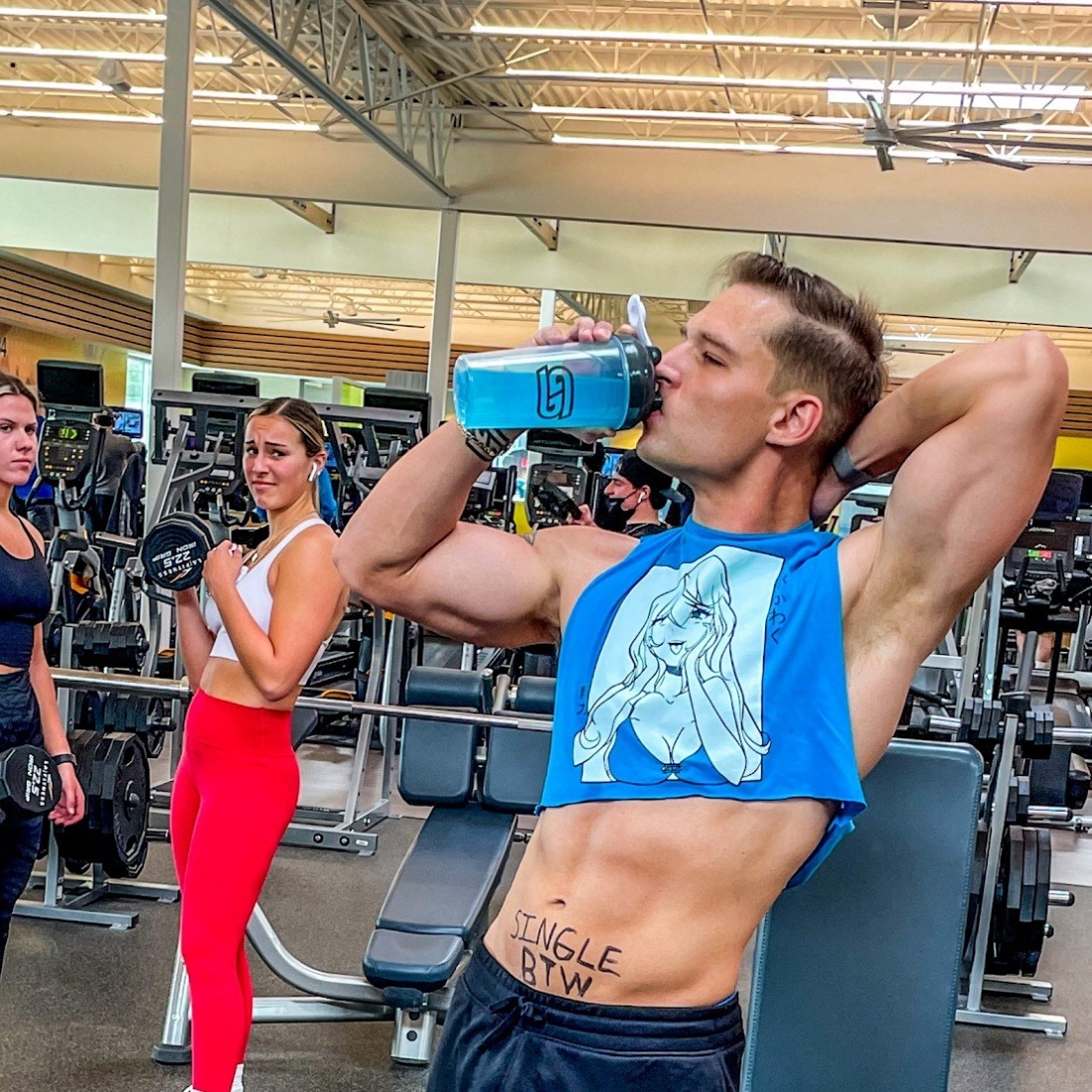 A person drinking from a blue container in a gym
Description automatically generated with low confidence